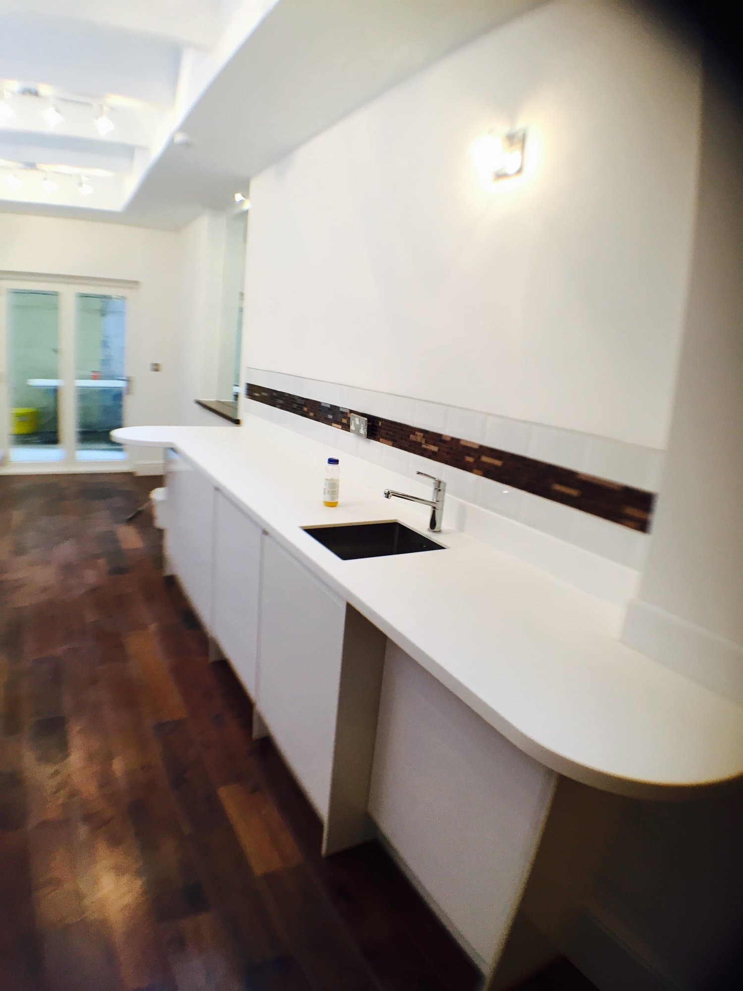 Curved white quartz breakfast bar with integrated sink